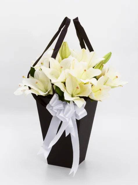 Arranjo de lirios brancos no cachepo preto